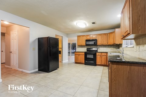 A kitchen with wooden cabinets and black appliances.