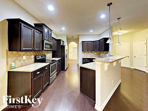 a large kitchen with dark wood cabinets and white counter tops