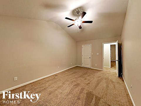 the master bedroom has a carpeted floor and a ceiling fan