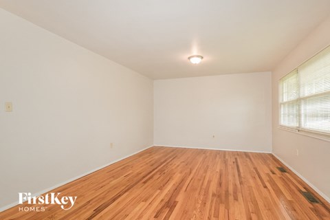 the spacious living room with hardwood floors and a large window