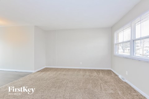 a bedroom with a carpet and two windows