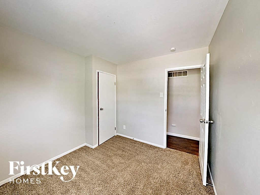 a bedroom with a closet and a door to a bathroom