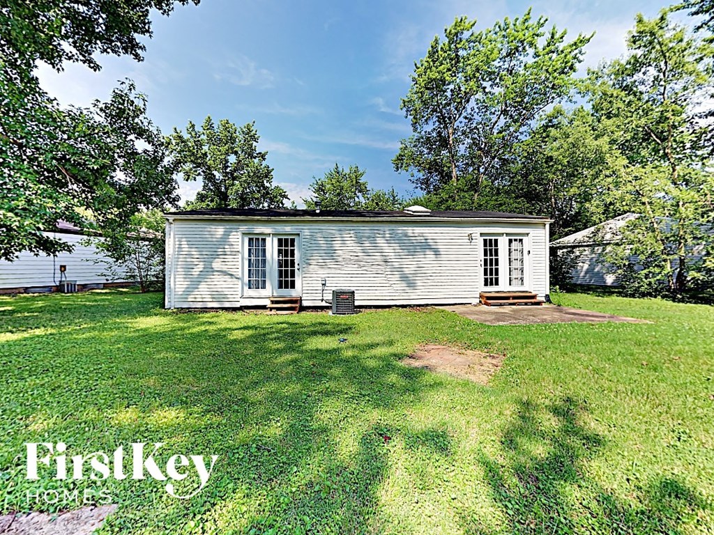 a small white house on the grass near the water