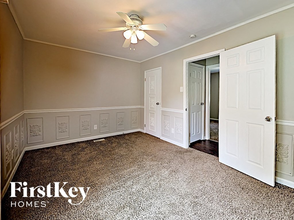 a empty bedroom with a ceiling fan and a closet