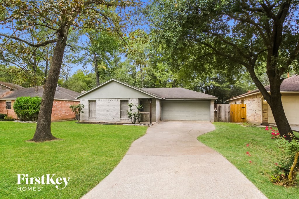 a street view of a house with trees and a sidewalk