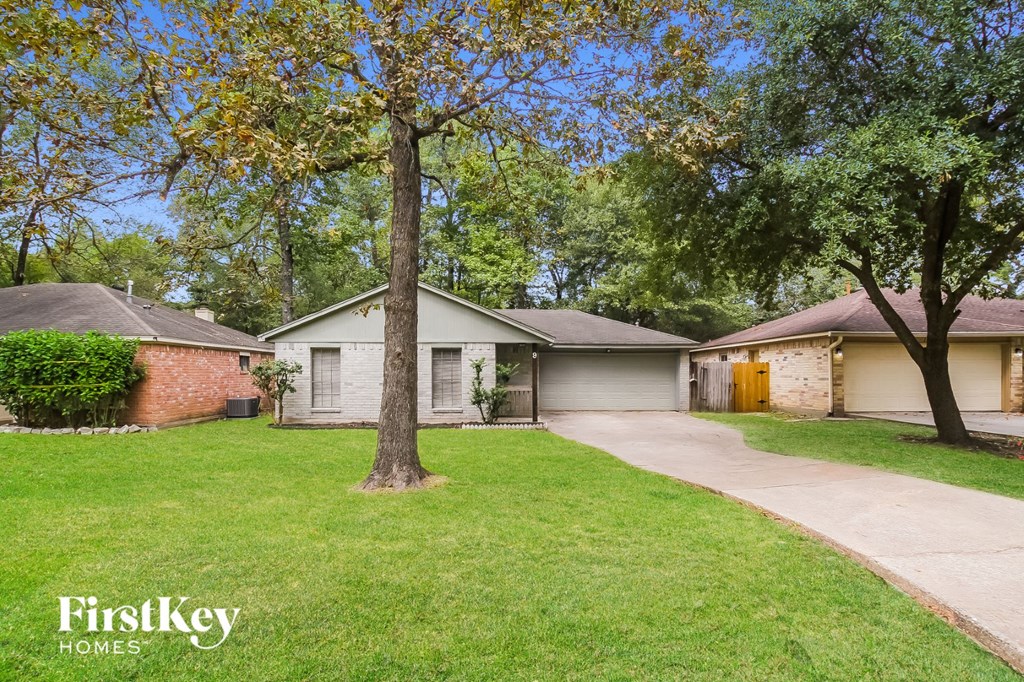 a house with a yard and a tree in front of it