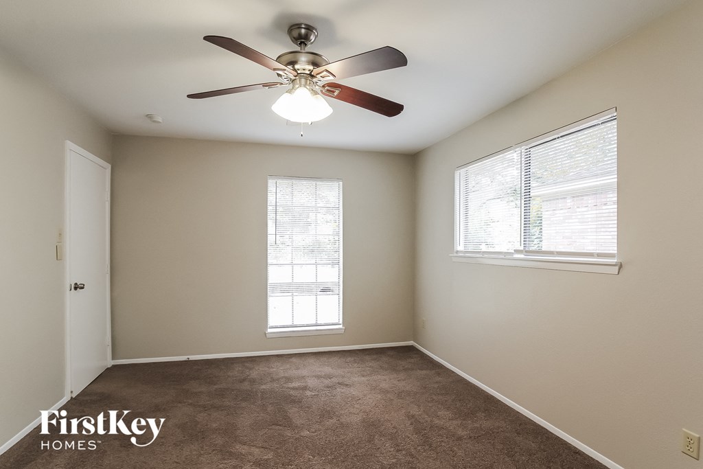 a bedroom with a ceiling fan and a window