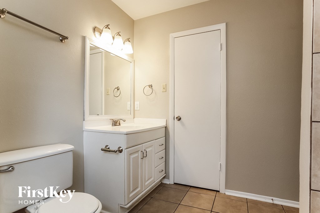 a bathroom with a toilet sink and mirror and a shower