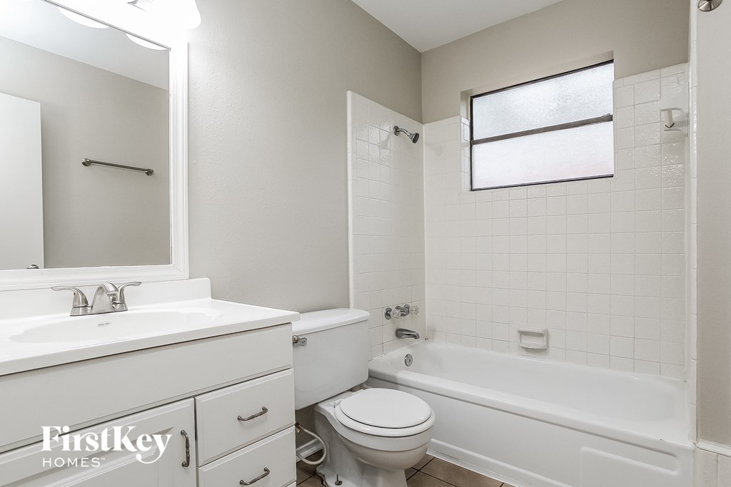 a white bathroom with a white toilet and tub and a sink