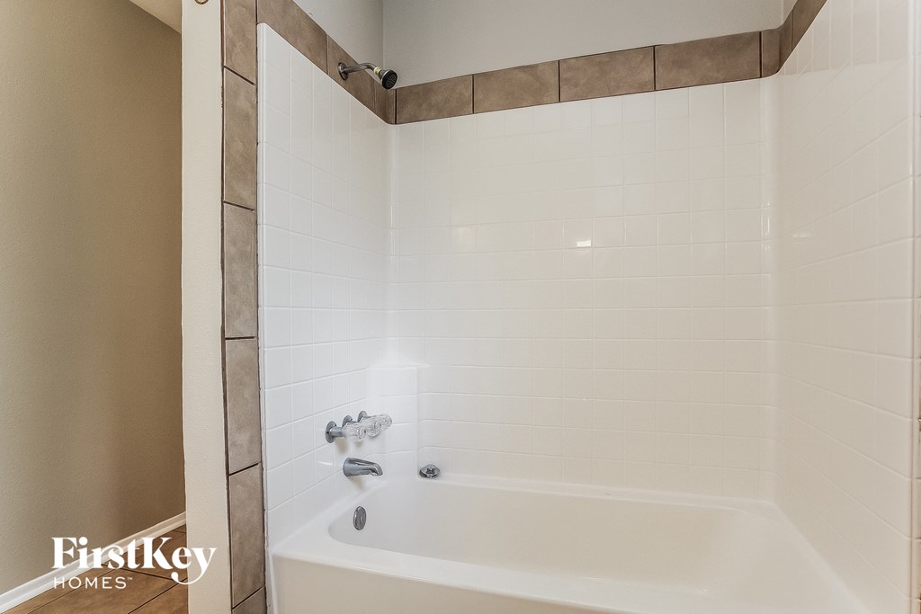 a white bath tub in a bathroom with white tile