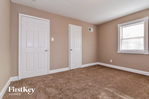 a bedroom with a carpeted floor and two white doors