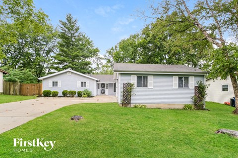 a white house with a yard and a driveway