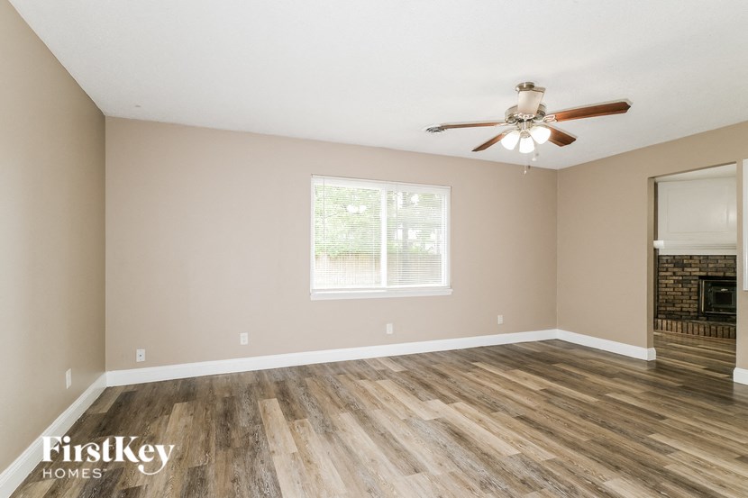 a living room with wood floors and a ceiling fan