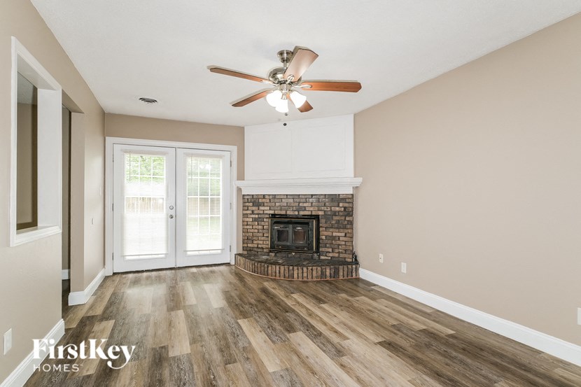 a living room with a fireplace and a ceiling fan