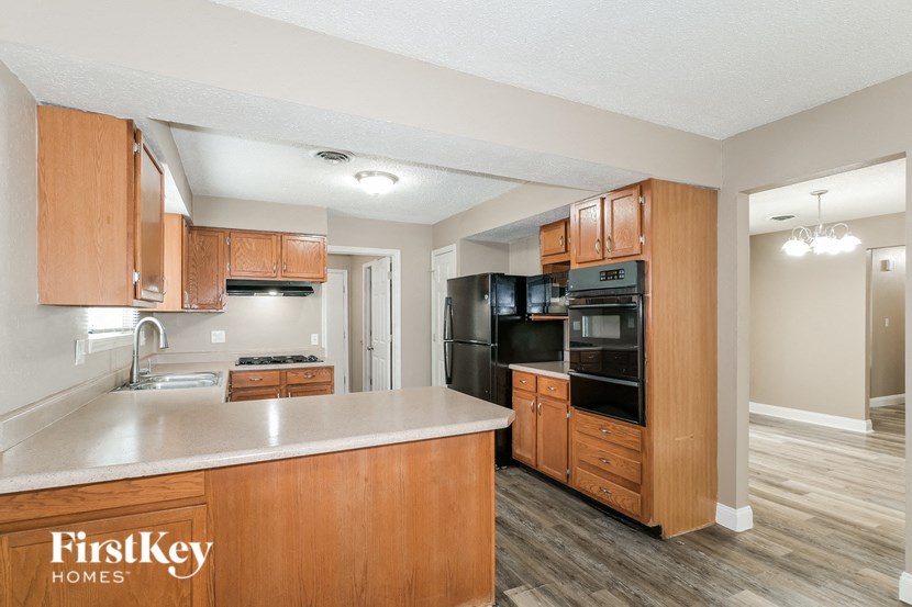 a kitchen with wooden cabinets and a white counter top