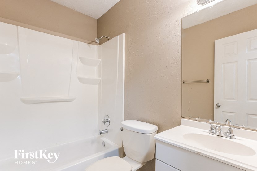 a bathroom with a toilet sink and tub and a mirror