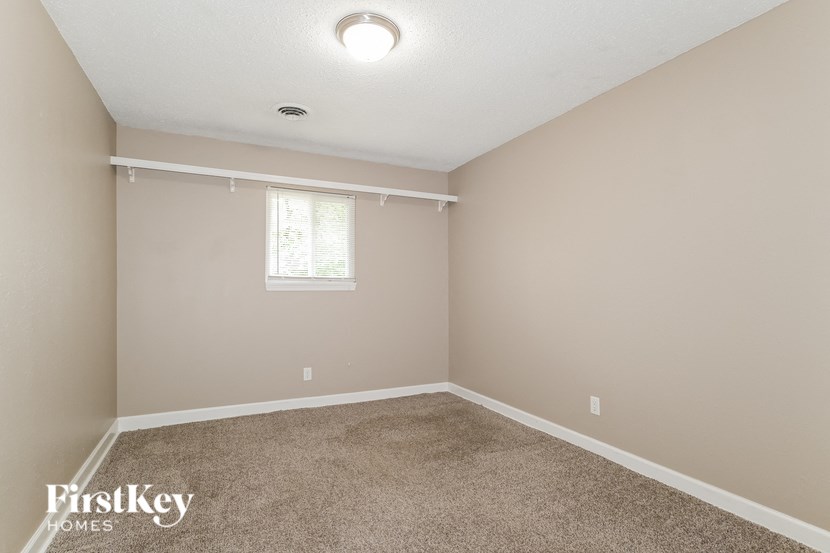 a empty room with carpet and a window