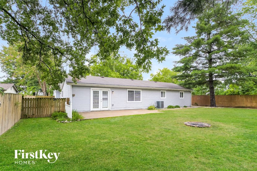a small white house with a yard and a fence