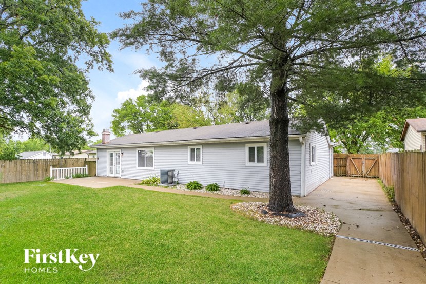 a white house with a yard and a tree