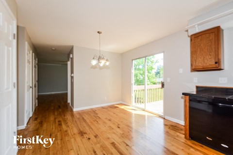A kitchen with wooden floors and a black counter top.