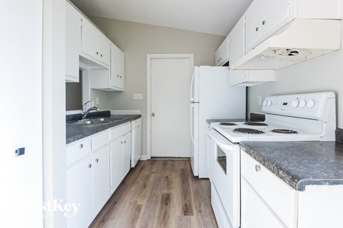 A kitchen with white appliances and cabinets.