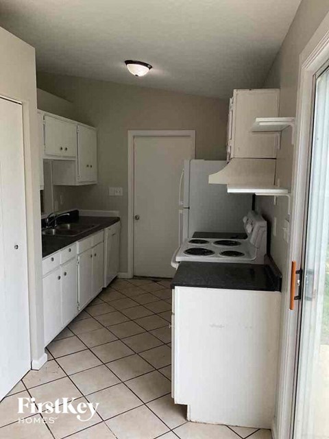 A kitchen with white appliances and cabinets.