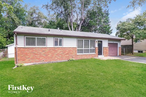 A house with a red door and a brick wall is for sale.