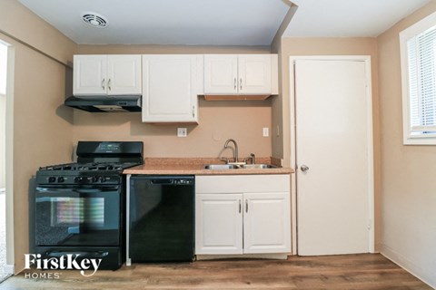 A kitchen with a black stove top oven and a black dishwasher.