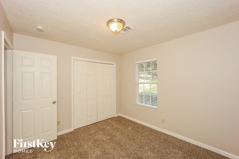 a bedroom with two doors and a carpeted floor