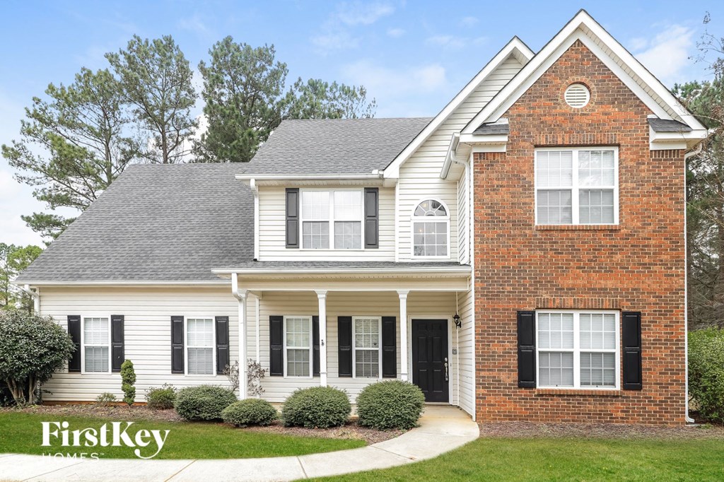 a white house with black shutters and a lawn