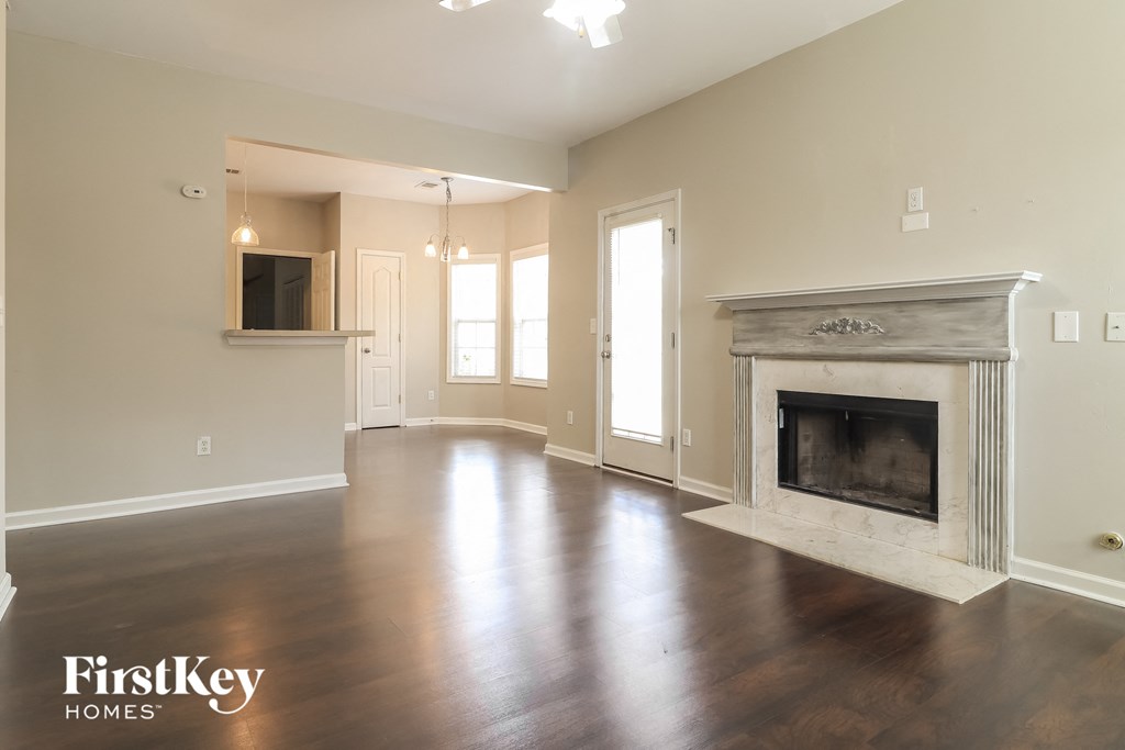 an empty living room with a fireplace and a tv
