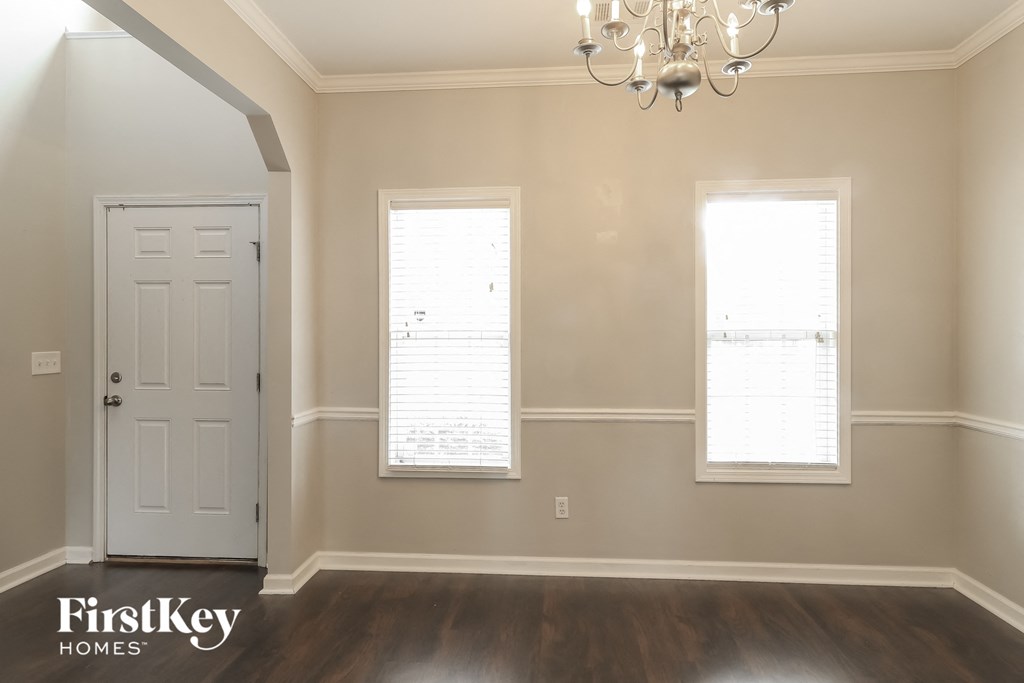 a dining room with a white door and two windows