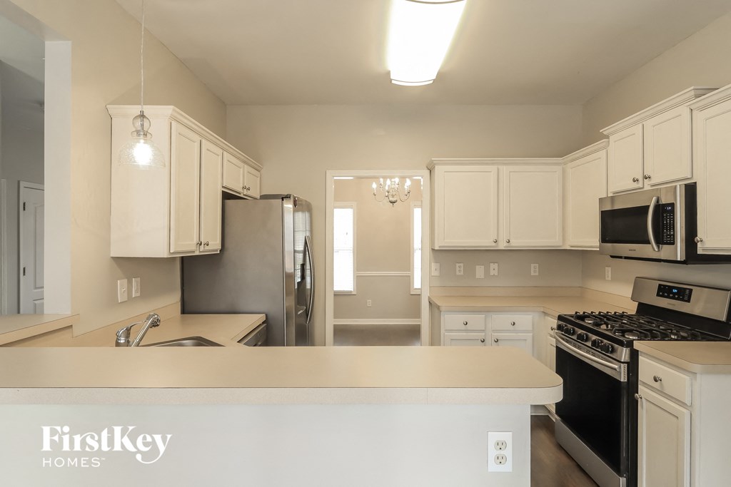 a kitchen with white cabinets and stainless steel appliances