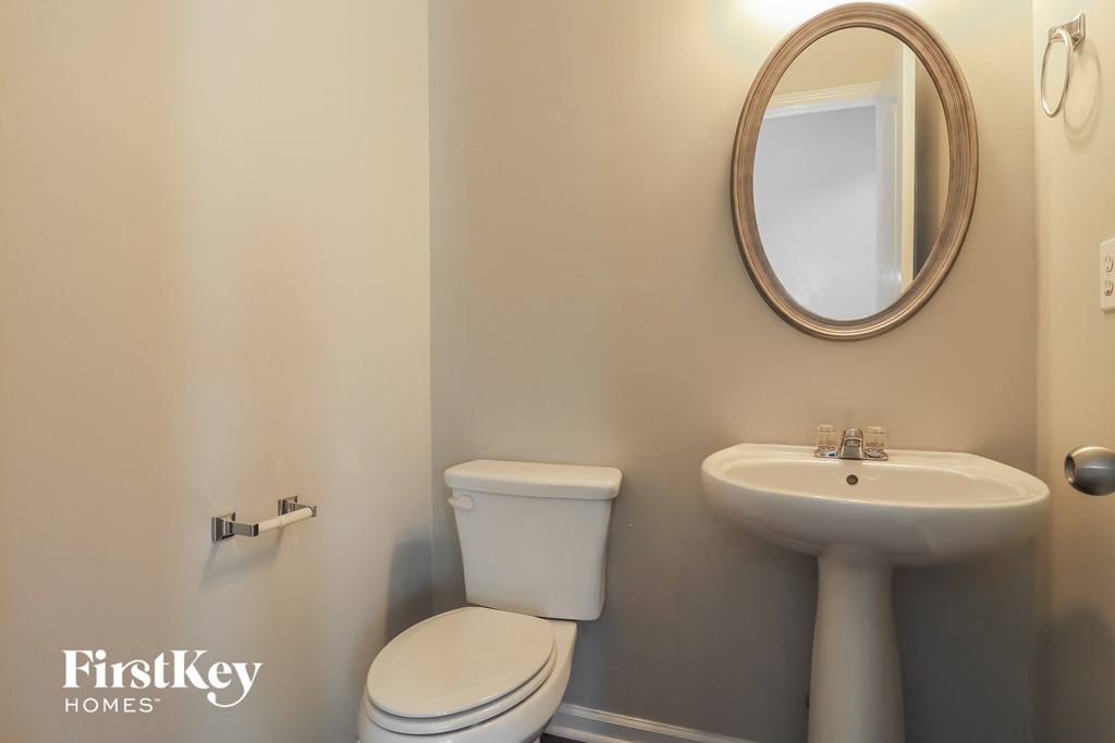 a bathroom with a toilet and a sink and a mirror