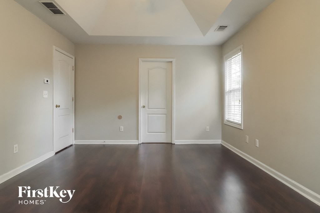 an empty living room with wood floors and white walls