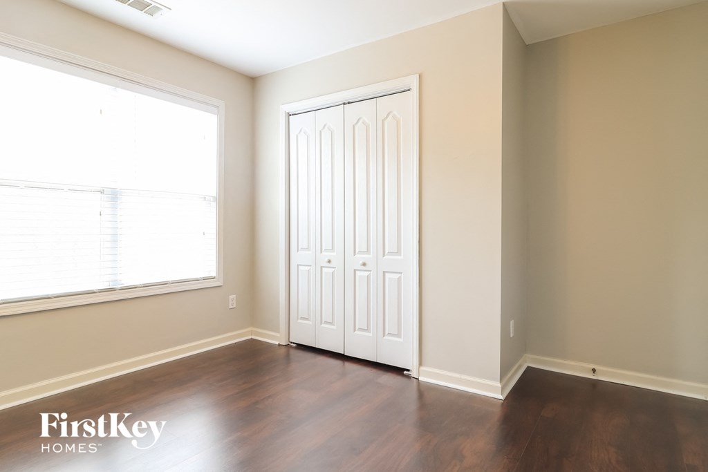 a living room with wood floors and a white door and a window