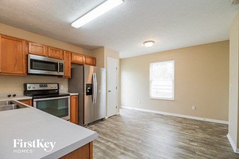 A kitchen with wooden cabinets and a stainless steel refrigerator.