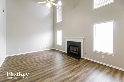 A spacious room with a fireplace and a ceiling fan.