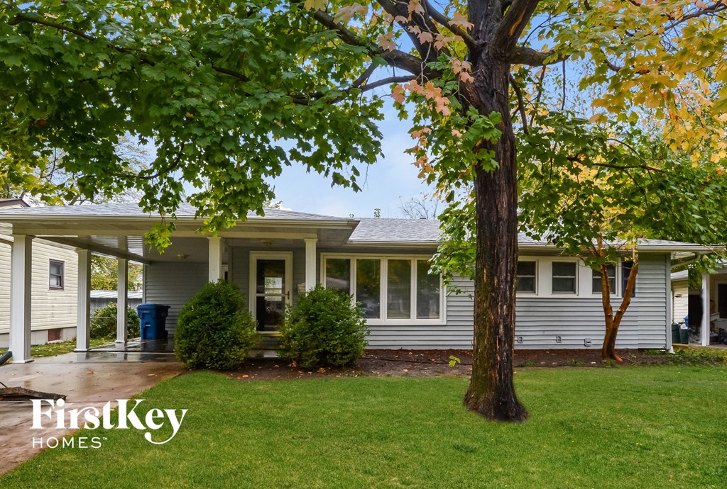 a white house with a tree in front of it