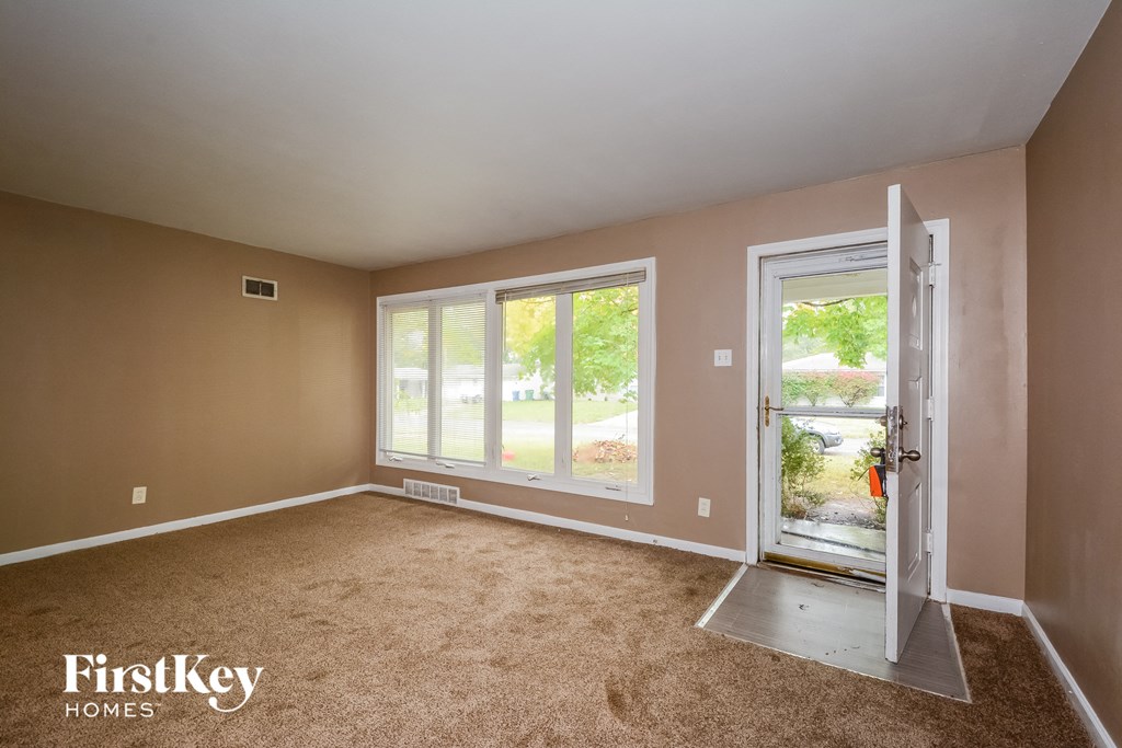 an empty living room with a door to a patio