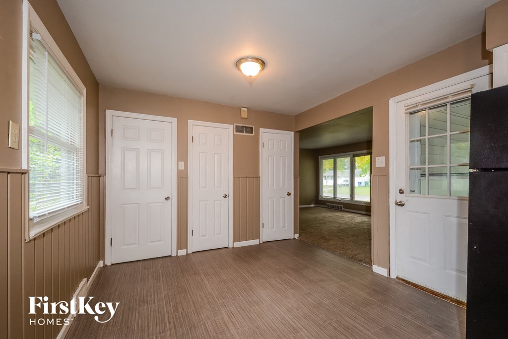 an empty living room with white doors and a window