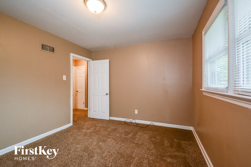a bedroom with a carpeted floor and a door to a closet