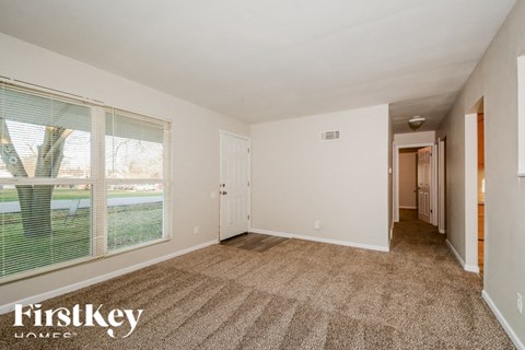 A room with a carpeted floor and a sliding glass door.