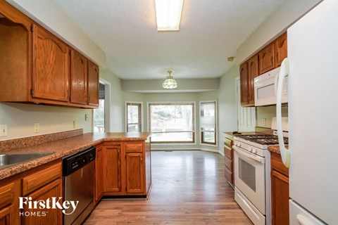 A kitchen with wooden cabinets and a white refrigerator.
