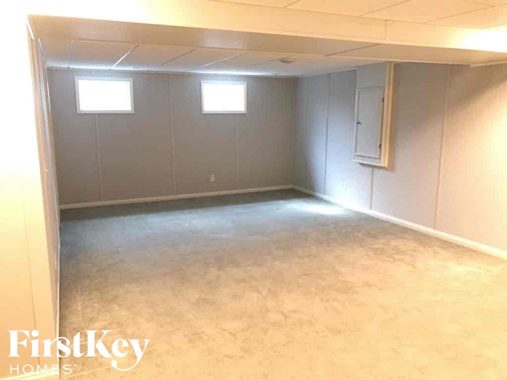 an empty basement with a concrete floor and gray walls