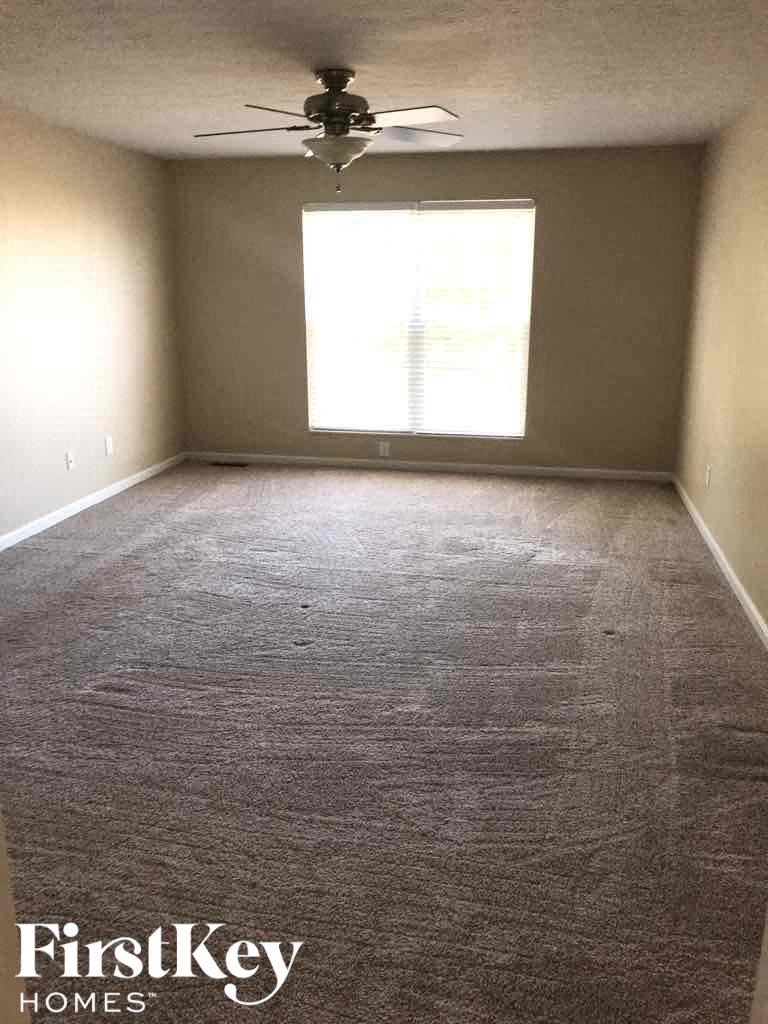 an empty room with a ceiling fan and a window