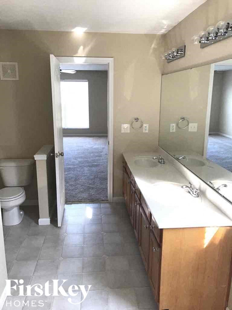 a bathroom with a toilet and a sink and a mirror