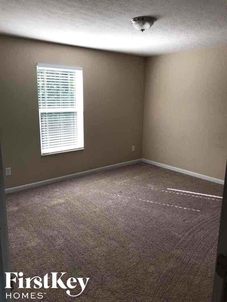 an empty room with carpet and a window