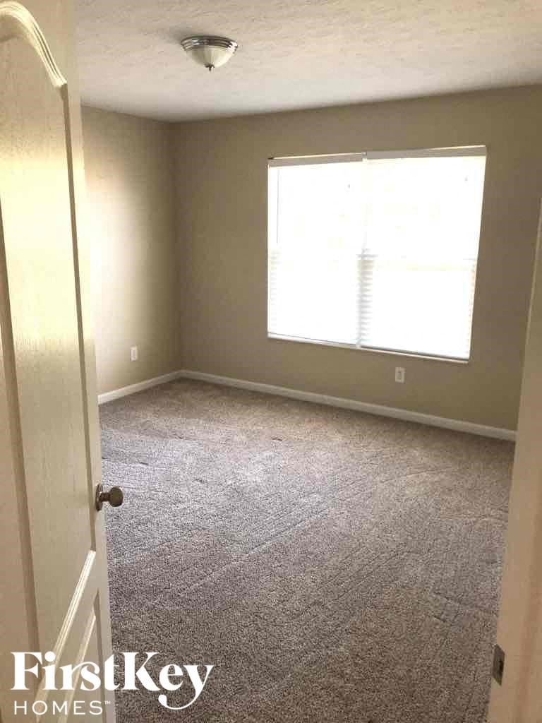 an empty room with carpet and a window