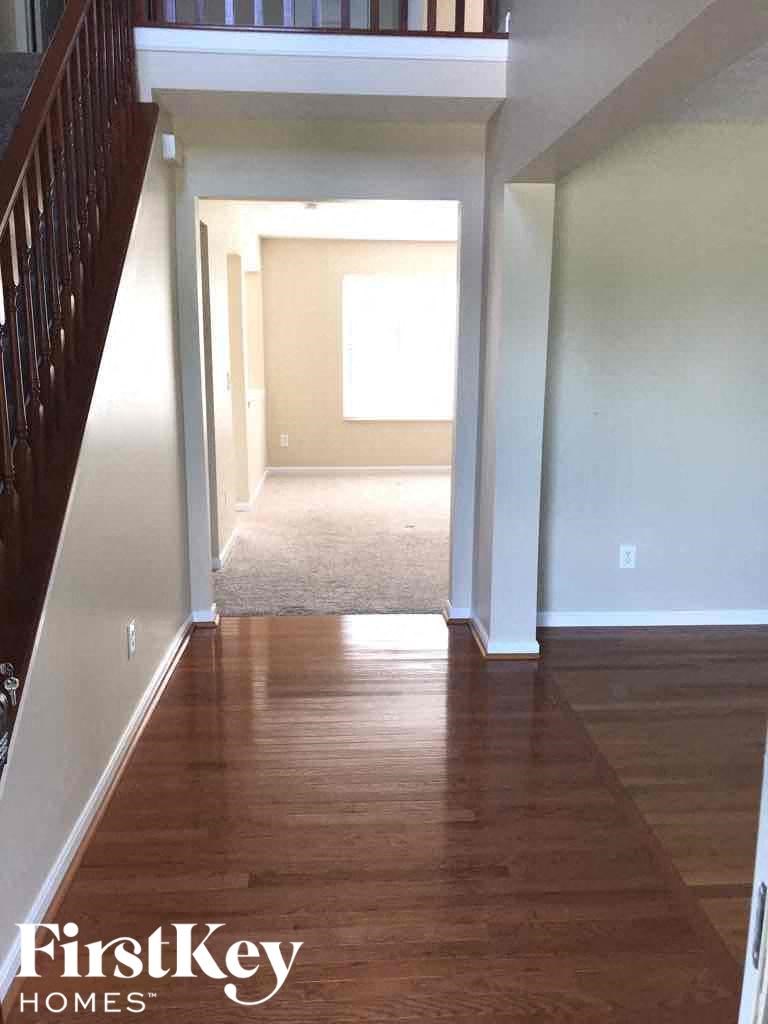 a view of a hallway from a house with wood floors